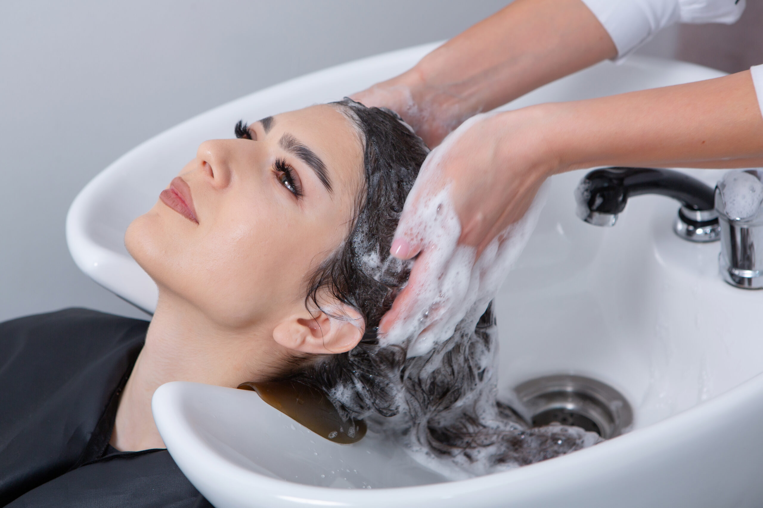 Home vecteezy professional hairdresser washing hair of young woman in 19934975